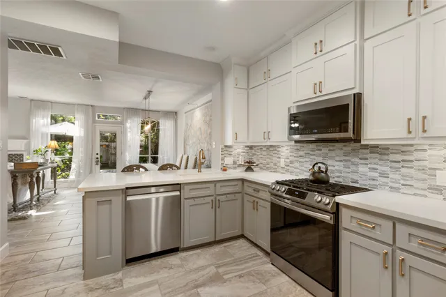 a kitchen with stainless steel appliances granite countertop a sink and stove top oven