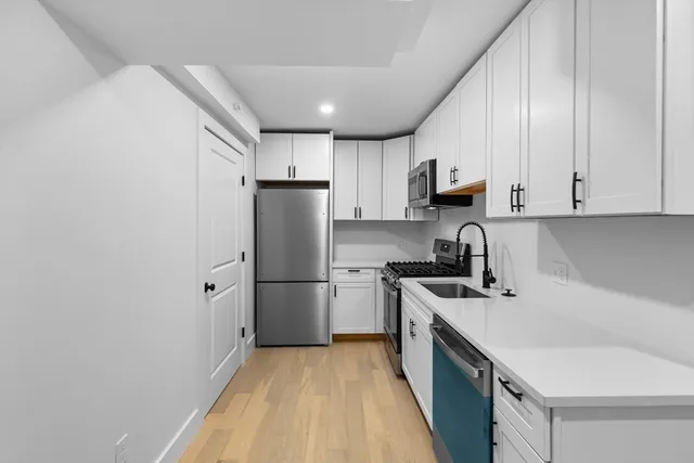 a kitchen with stainless steel appliances granite countertop a sink stove and refrigerator