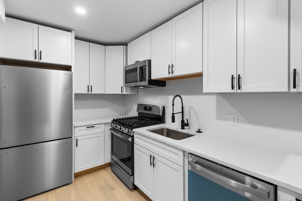 20 Orne Street, Unit B North Attleboro, MA 02760 - Photo 9 of 16 a kitchen with stainless steel appliances white cabinets and a refrigerator