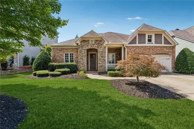 a front view of a house with a garden and plants