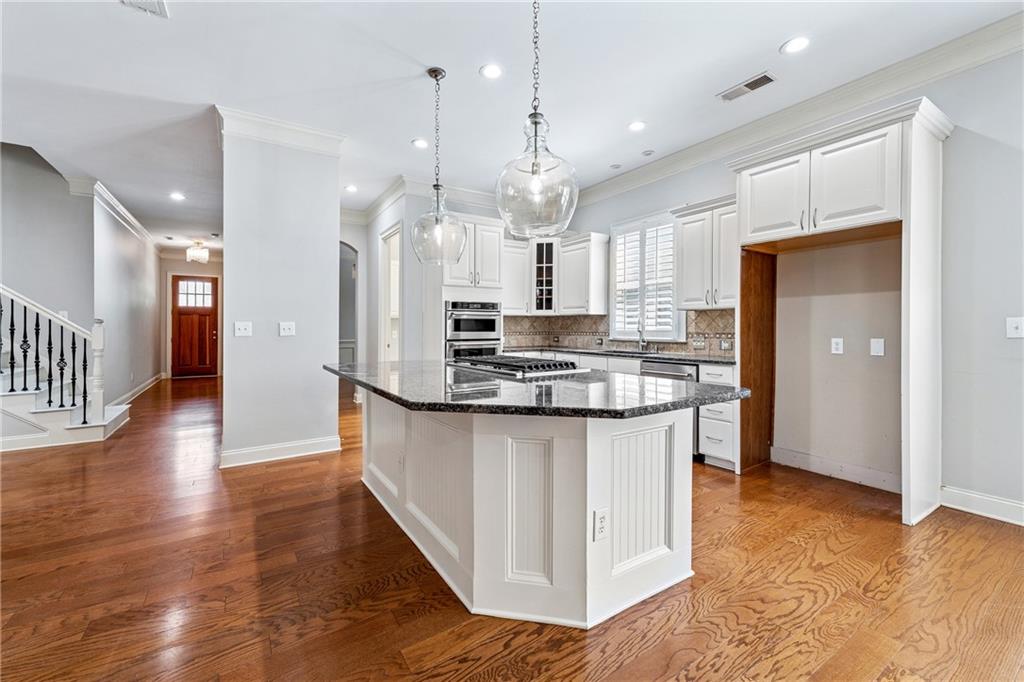 4865 Chase Lane Cumming, GA 30040 - Photo 13 of 70 a kitchen with stainless steel appliances granite countertop a refrigerator a sink a stove and a wooden floors