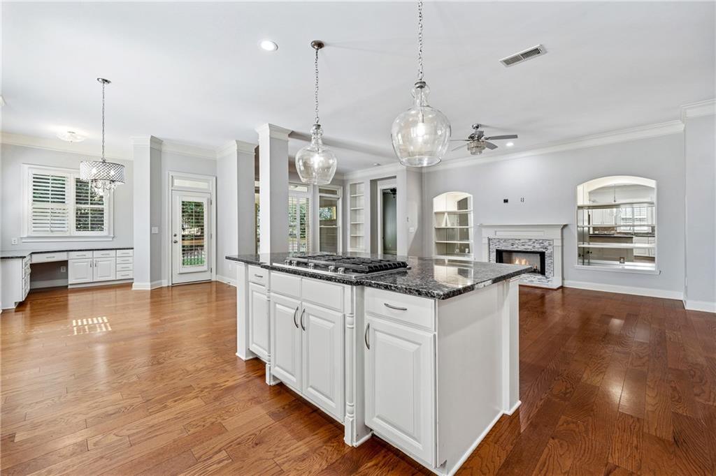 4865 Chase Lane Cumming, GA 30040 - Photo 15 of 70 a large kitchen with stainless steel appliances granite countertop a stove and a wooden floors