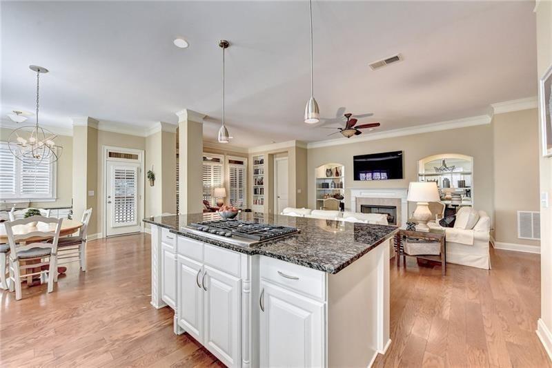 4865 Chase Lane Cumming, GA 30040 - Photo 16 of 70 a kitchen with stainless steel appliances granite countertop a stove and a wooden floors