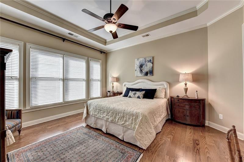 4865 Chase Lane Cumming, GA 30040 - Photo 31 of 70 a bedroom with a large bed chandelier and a window