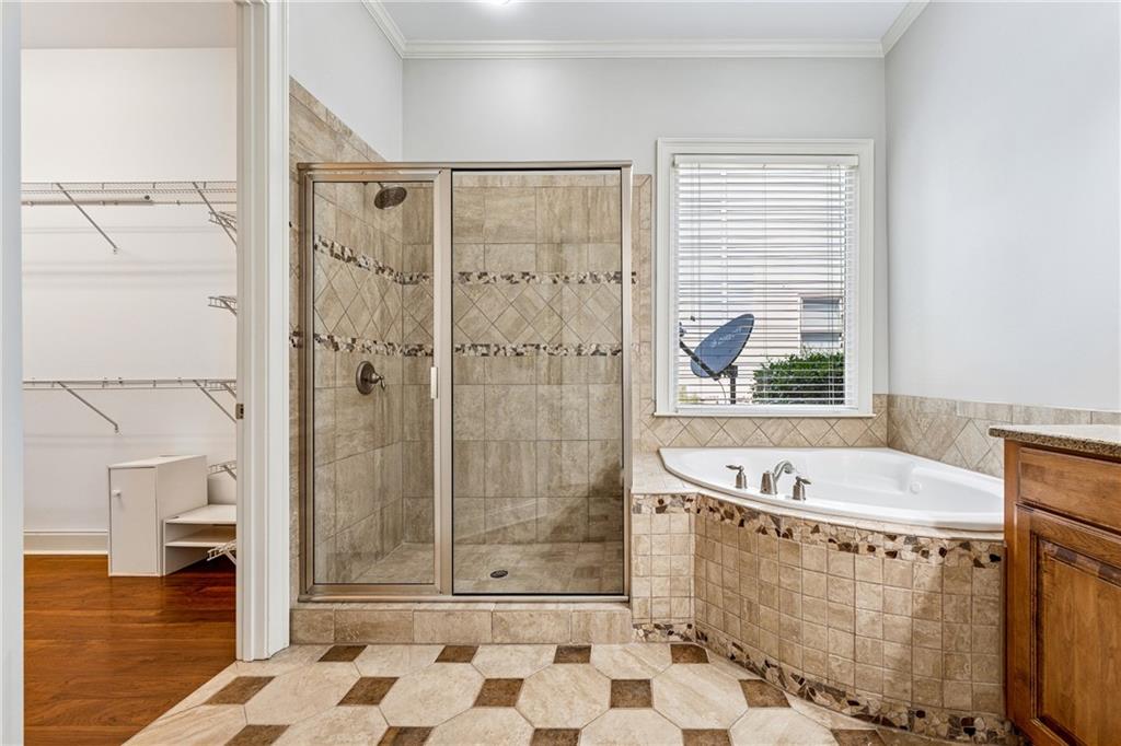 4865 Chase Lane Cumming, GA 30040 - Photo 35 of 70 a bathroom with a tub a sink and a shower