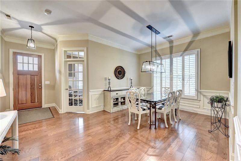 4865 Chase Lane Cumming, GA 30040 - Photo 7 of 70 a dining room with wooden floor a chandelier a wooden table and chairs