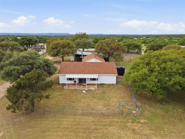 an aerial view of a house with a yard and lake view