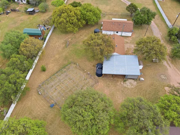 an aerial view of a house with a yard and a fountain