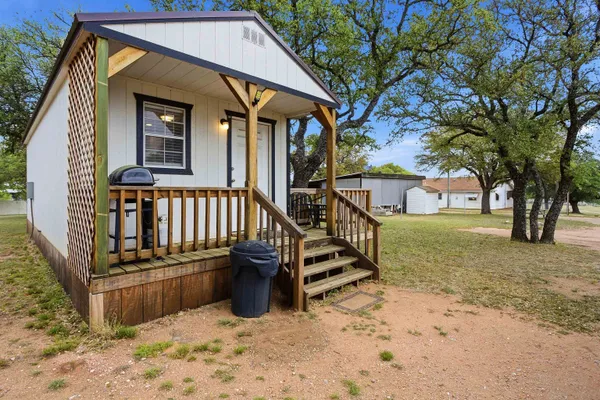 a view of a house with backyard and trees
