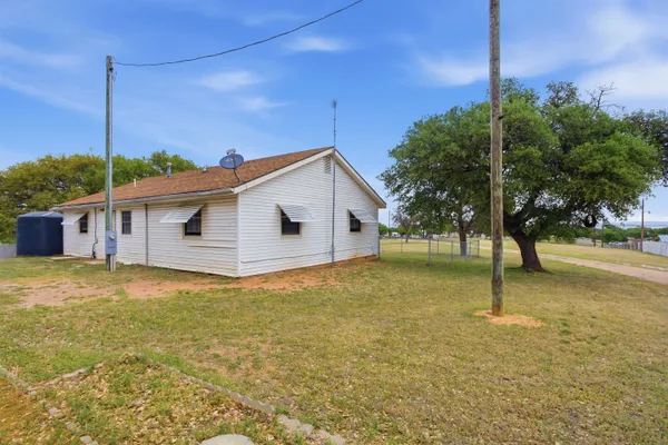 a view of a house with a yard and tree