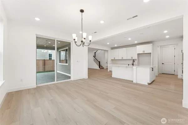 a view of a kitchen with refrigerator and white cabinets