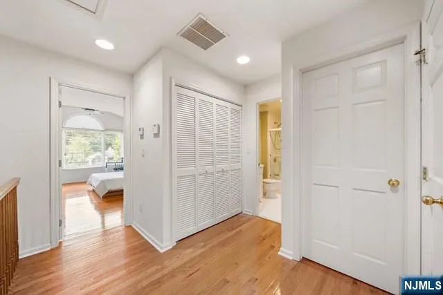 a view of a hallway with wooden floor and a cabinet