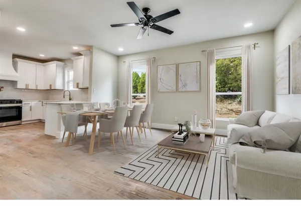 a living room with furniture a wooden floor and a window