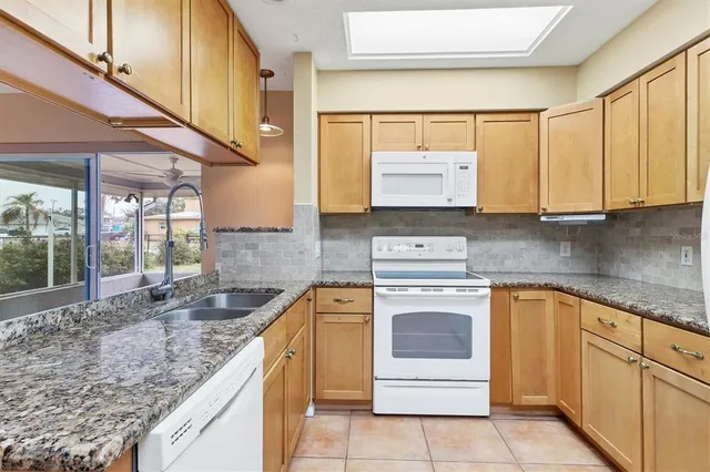 a kitchen with stainless steel appliances granite countertop a stove sink and cabinets