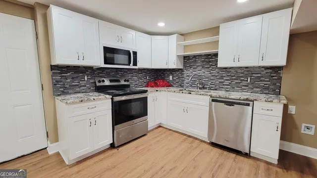 a kitchen with white cabinets stainless steel appliances and sink