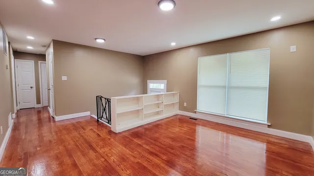 a view of empty room with wooden floor