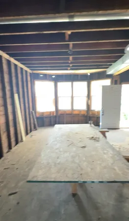 a view of empty room with floor to ceiling windows and plants