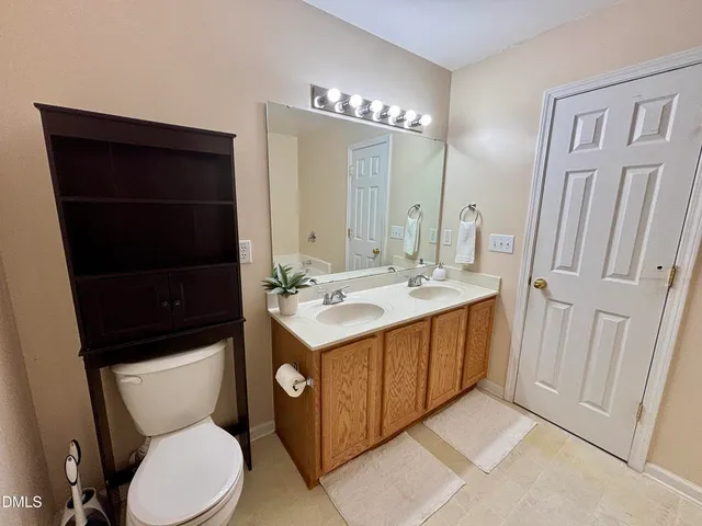 a bathroom with a sink a toilet a mirror and shower