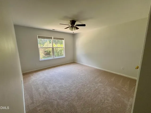 an empty room with windows and ceiling fan view