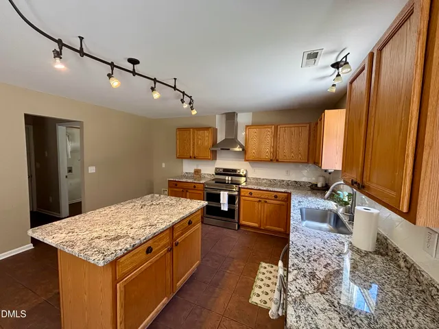 a open kitchen with stainless steel appliances granite countertop plenty wooden cabinets counter space and view of living room