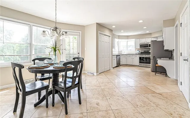 a dining room well furnished livingroom with furniture and large windows