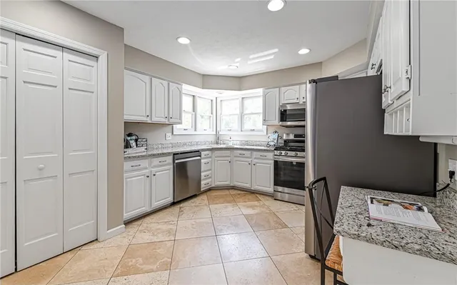 a kitchen with stainless steel appliances granite countertop a stove a sink a microwave and a refrigerator