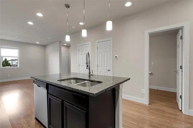 a kitchen with granite countertop stainless steel appliances a stove sink microwave and window