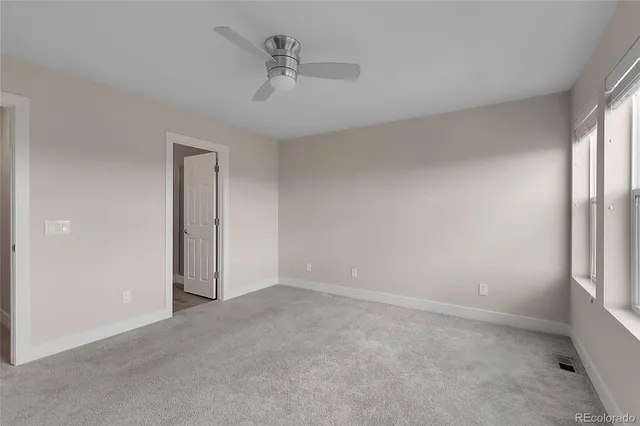 a view of an empty room and a ceiling fan