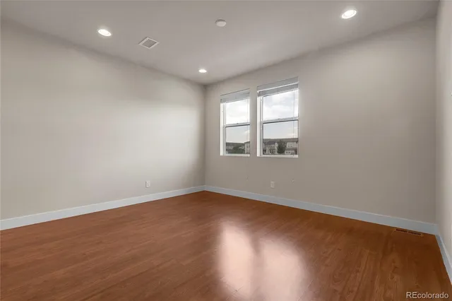 a view of kitchen with kitchen island a sink wooden floor and chairs