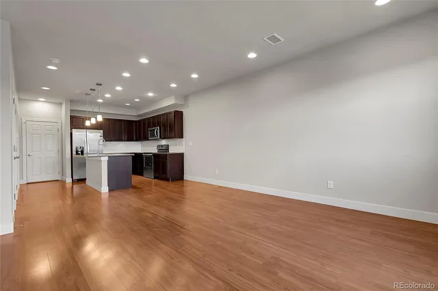 a view of kitchen with kitchen island wooden floor and center island