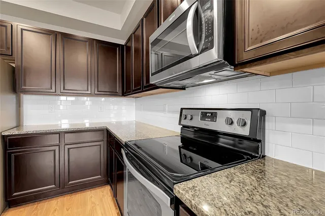 a kitchen with kitchen island granite countertop stainless steel appliances cabinets a sink and a counter space
