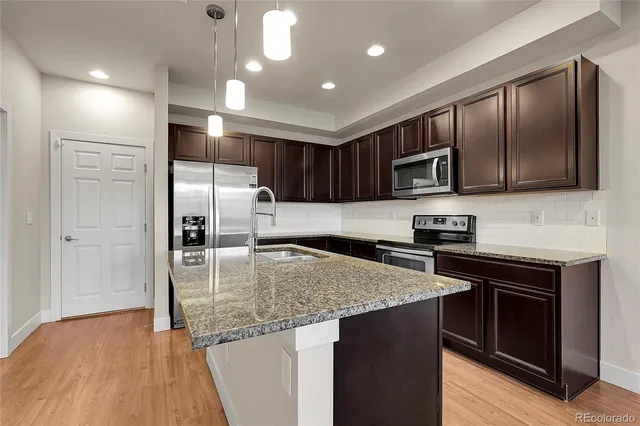 a kitchen that has a sink cabinets and wooden floor