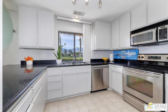 a kitchen with stainless steel appliances white cabinets and a sink