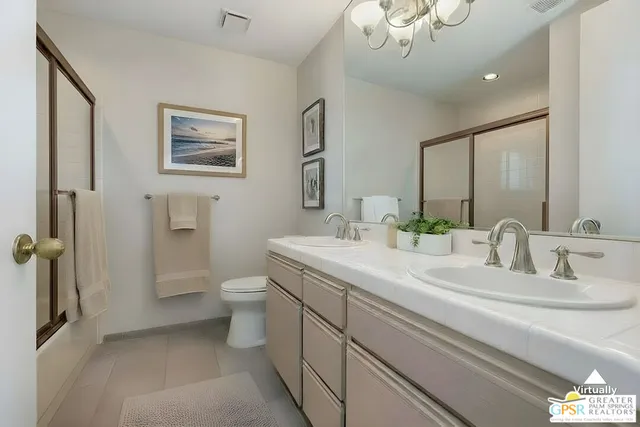 a bathroom with a double vanity sink mirror and toilet