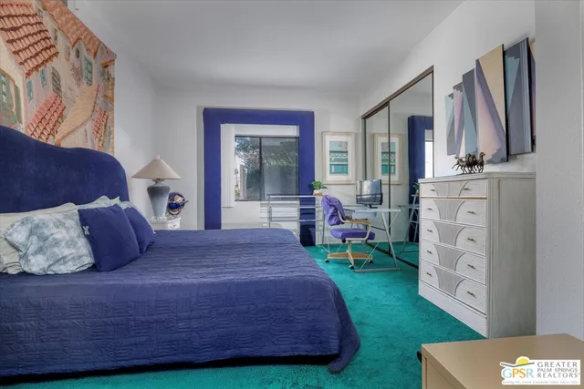 a bedroom with a bed dresser and a large window