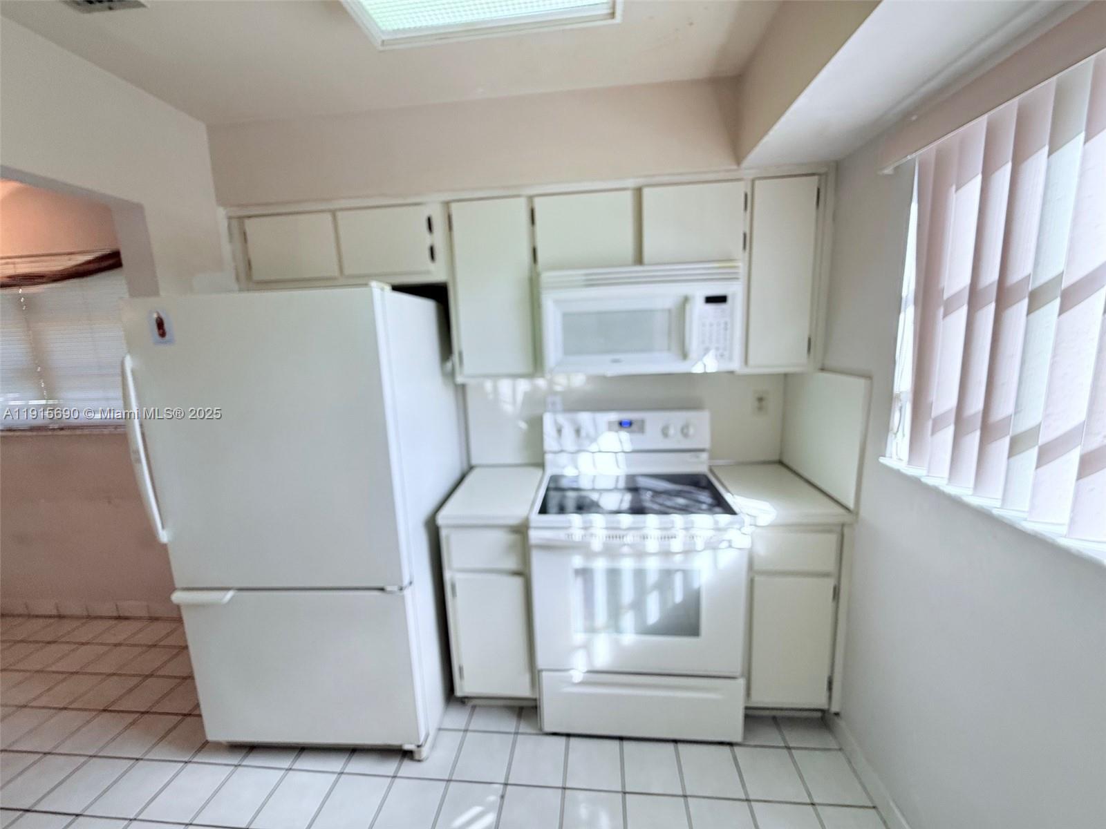 6225 Southwest 136th Court, Unit C209 Miami, FL 33183 - Photo 3 of 13 a kitchen with a stove top oven and refrigerator