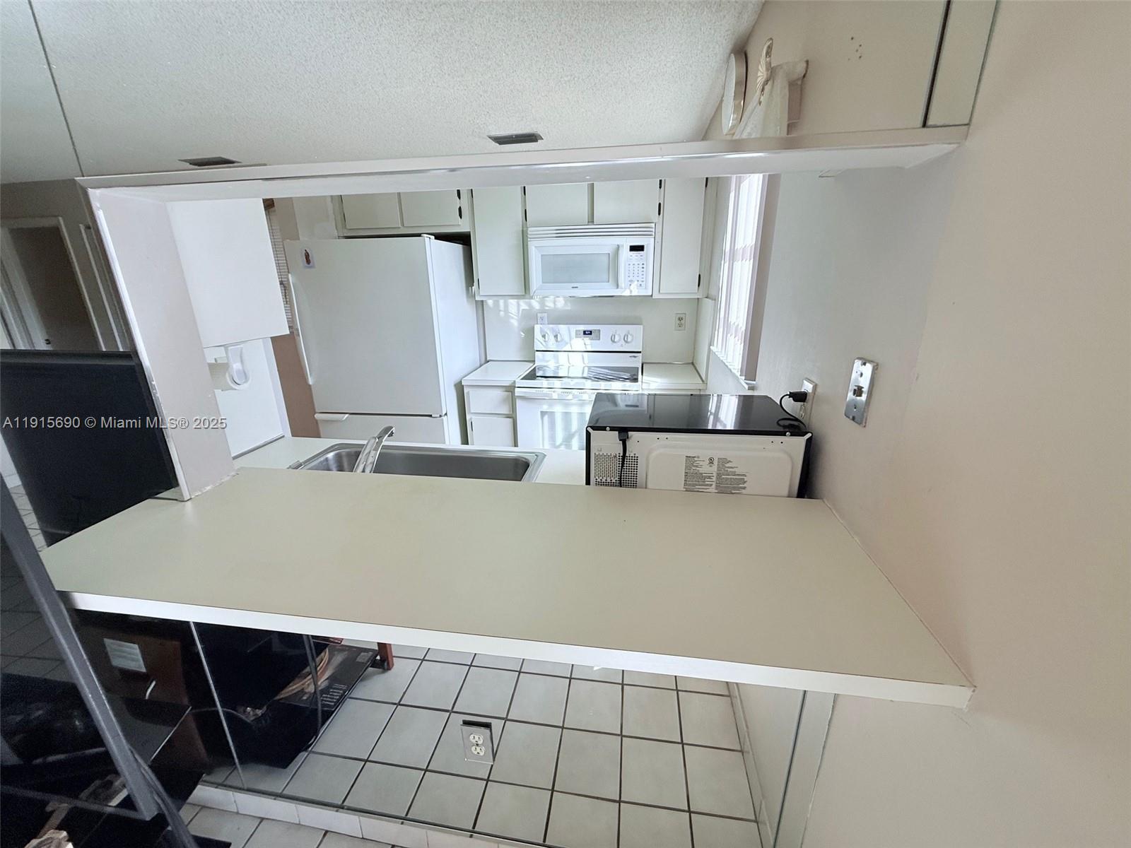 6225 Southwest 136th Court, Unit C209 Miami, FL 33183 - Photo 5 of 13 a room with table and chairs