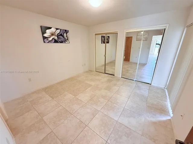 an empty room with windows and closet