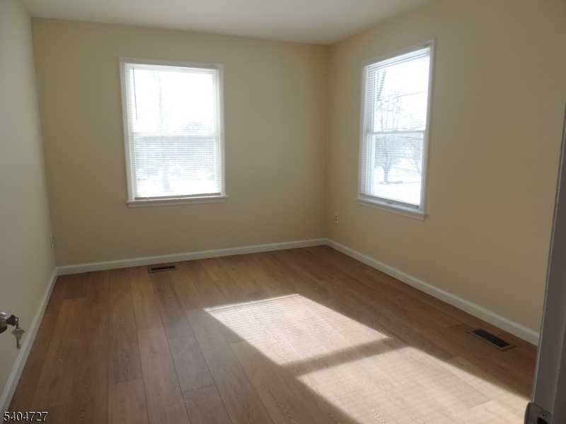 27 Alexandria Way, Unit 27 Bernards, NJ 07920 - Photo 14 of 19 an empty room with wooden floor and windows