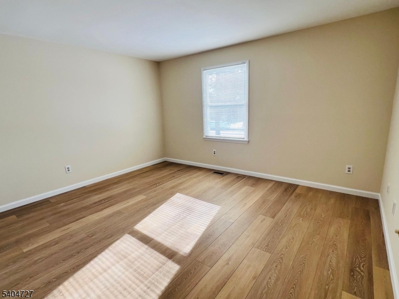 27 Alexandria Way, Unit 27 Bernards, NJ 07920 - Photo 16 of 19 an empty room with wooden floor and windows