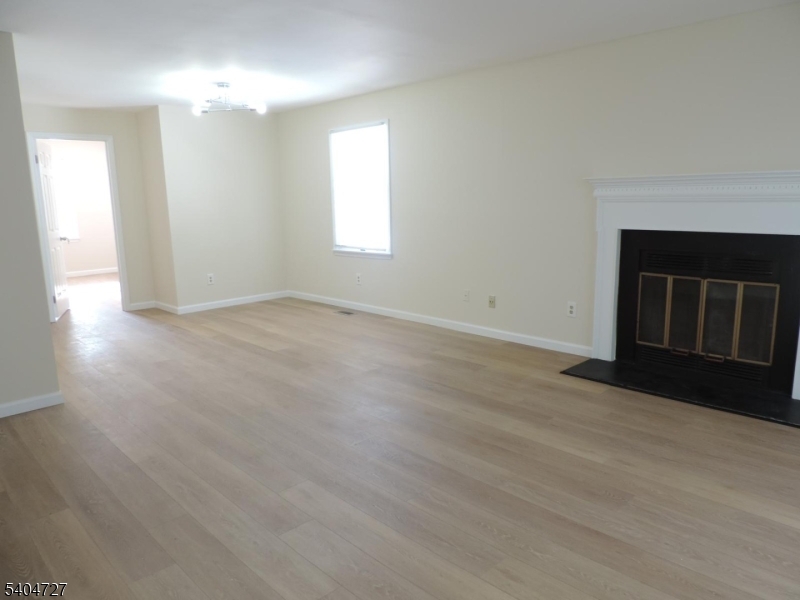 27 Alexandria Way, Unit 27 Bernards, NJ 07920 - Photo 4 of 19 an empty room with wooden floor and windows