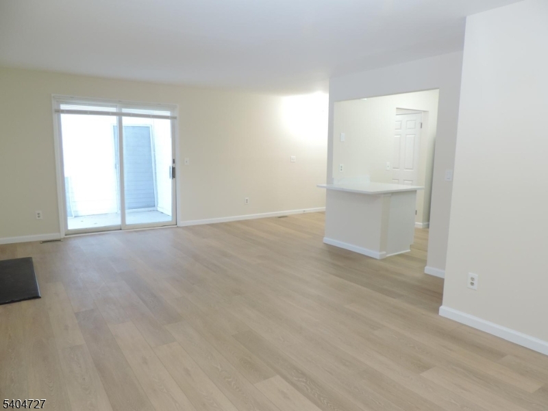 27 Alexandria Way, Unit 27 Bernards, NJ 07920 - Photo 6 of 19 a view of an empty room with wooden floor and a window
