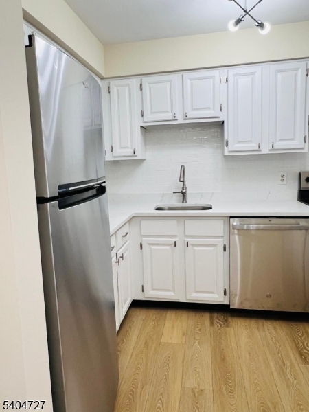 27 Alexandria Way, Unit 27 Bernards, NJ 07920 - Photo 7 of 19 a kitchen with white cabinets and refrigerator