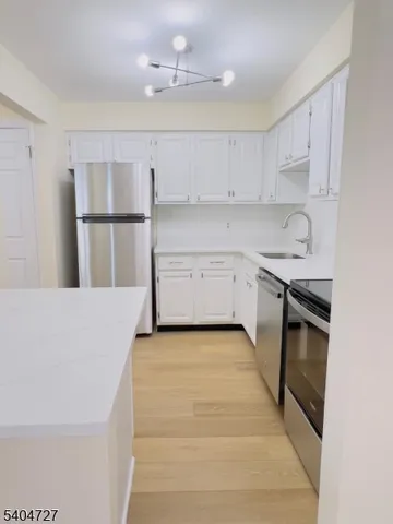 a kitchen with granite countertop a sink a stove and cabinets