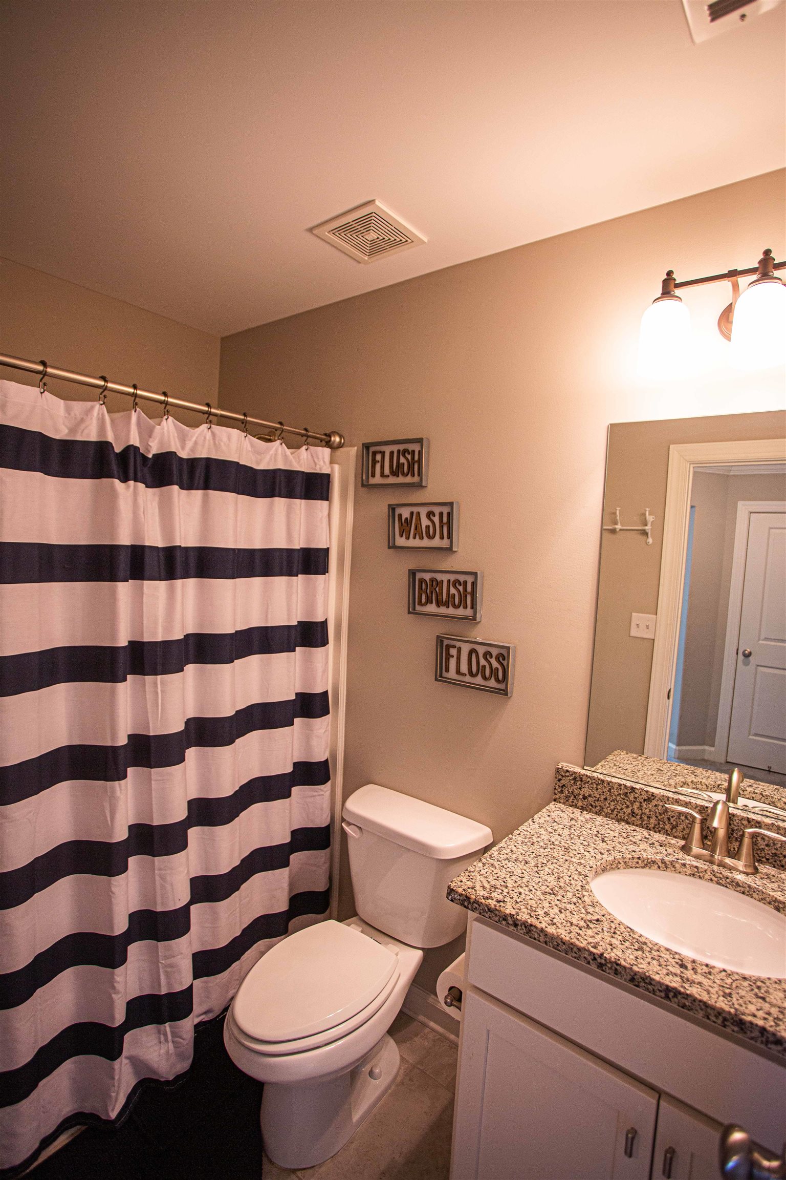 6314 Burren Way Arlington, TN 38002 - Photo 19 of 25 a bathroom with a granite countertop toilet a sink and a mirror