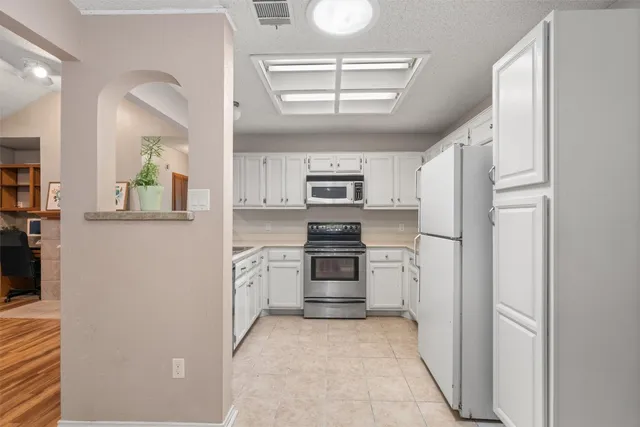 a kitchen with stainless steel appliances granite countertop a refrigerator and a stove top oven