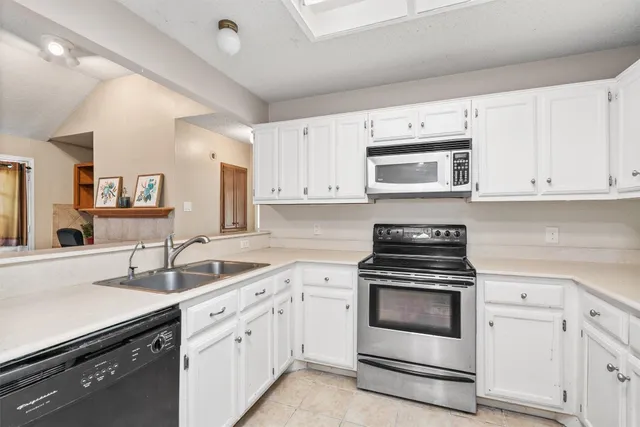 a kitchen with white cabinets and white appliances