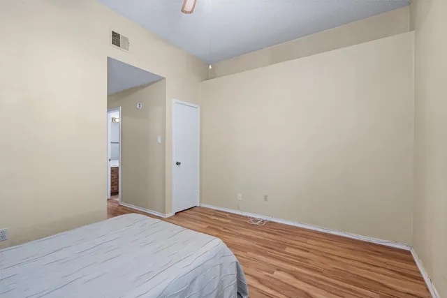 a room with a bed and wooden floor