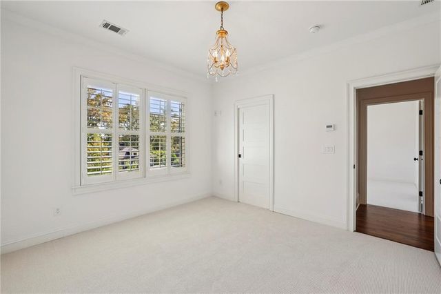 a view of an empty room with closet and entryway