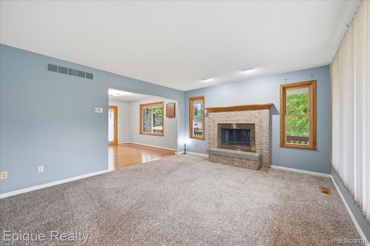 1221 Rhodes Road Lake Orion, MI 48360 - Photo 22 of 72 Living room featuring a brick fireplace with a wood mantle, recessed lighting, and carpet flooring